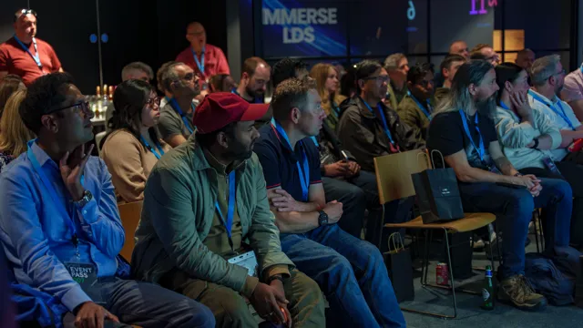Engineers and tech leaders seated in Flutter's immersive zone, lanyards on, watching the live demo unfold on the wraparound screens